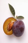 Halved plum with drops of water — Stock Photo