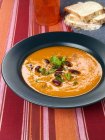 Pumpkin soup with beans in black plate — Stock Photo