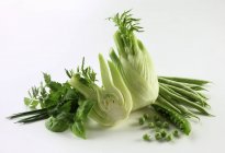 Still life with green vegetables and herbs over white background — Stock Photo