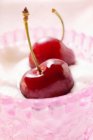 Fresh cherries on whipped cream — Stock Photo