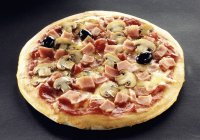 Pizza con jamón, champiñones y aceitunas - foto de stock