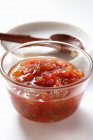Pepper relish in small glass bowl over white background — Stock Photo