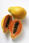 Whole and half papayas — Stock Photo