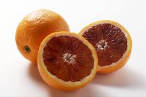 Whole and half blood oranges — Stock Photo