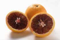 Whole and half blood oranges — Stock Photo