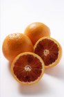 Naranjas enteras y medias de sangre - foto de stock