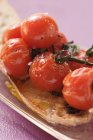 Tomates cerises cuites sur du pain blanc sur un plateau sur une surface violette — Photo de stock