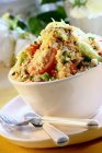 Кус-салат з овочами в білій мисці над тарілкою з виделкою та ножем — стокове фото