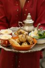 Vista ritagliata della donna che serve pollo con couscous, fagioli e lenticchie — Foto stock