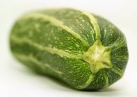 A raw vegetable marrow on white background — Stock Photo
