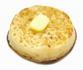Crumpet tostado com manteiga no fundo branco — Fotografia de Stock