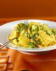 Noodles with broccoli, fish and saffron sauce — Stock Photo