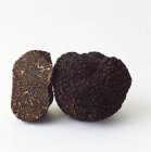 Whole and half black truffle — Stock Photo