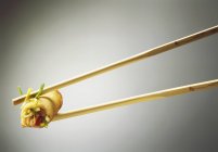 Chopsticks with spring roll — Stock Photo