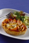 Peperoni, cipolle, prosciutto e mozzarella in astuccio su piatto bianco con forchetta su superficie blu — Foto stock