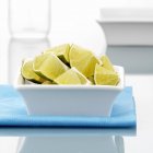 Lime quarters in small bowl — Stock Photo