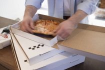 Uomo che prende un pezzo di pizza — Foto stock