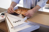 Человек берет кусок пиццы — стоковое фото
