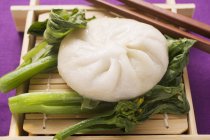 Filled yeast dumpling on pak choi — Stock Photo