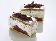 Крупним планом шматочки вишневого торта з шоколадом на білій рифленій поверхні — стокове фото