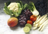 Барвистий натюрморт зі свіжих фруктів та овочів на мармуровій поверхні — стокове фото