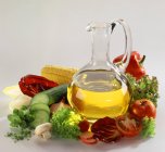 Still life with oil and salad ingredients on white background — Stock Photo