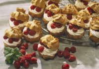 Closeup view of cream puffs with raspberries — Stock Photo