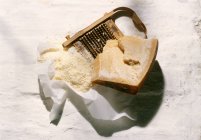 Шматок сиру пармезан з тертці — стокове фото
