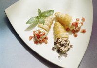 Primo piano vista di tre pasticcini ripieni di crema con frutta e cioccolato — Foto stock