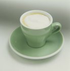 Closeup view of Capuccino in a green cup — Stock Photo