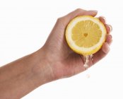 Рука, стискаючи лимон — стокове фото