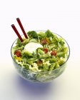 Чаша зеленого салата с помидорами, перцем и майонезом на белом фоне — стоковое фото