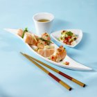 Крупный план Севиче с маринованной сырой рыбой, палочками для еды и напитками — стоковое фото
