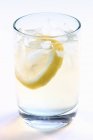 Склянка води з лимонним шматочком — стокове фото