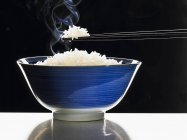 Готовый рис с палочками для еды — стоковое фото