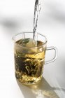 Acqua che viene versata nel bicchiere da tè — Foto stock
