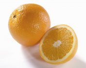Naranja fresco con la mitad - foto de stock
