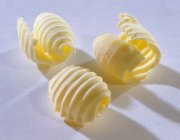 Nahaufnahme von drei Butterlocken auf weißer Oberfläche — Stockfoto