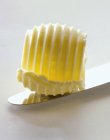 Vista close-up de um cachimbo de manteiga em uma lâmina de faca — Fotografia de Stock