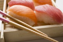 Sushi nigiri com pauzinhos — Fotografia de Stock