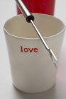 Vista de primer plano de vaso de precipitados con la palabra amor y tenedor fondue - foto de stock