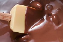 Крупный план расплавленного шоколада со смешивающей ложкой — стоковое фото