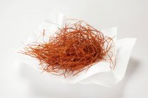 Saffron threads on paper — Stock Photo