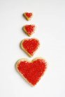 Galletas en forma de corazón decoradas con azúcar roja - foto de stock