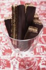 Vue rapprochée du chocolat et des tranches simples avec glaçage au chocolat en verre — Photo de stock