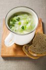 Leek cream soup with bread and spoon — Stock Photo