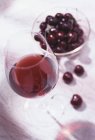 Glas Rotwein und Kirschen — Stockfoto