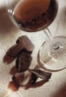 Vino rosso in bicchiere con pezzi di cioccolato — Foto stock