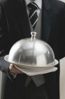 Vista ritagliata del cameriere servire piatto sotto copertura cupola — Foto stock