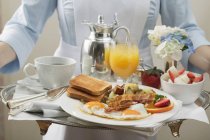 Vue recadrée de la femme de chambre portant plateau de petit déjeuner — Photo de stock